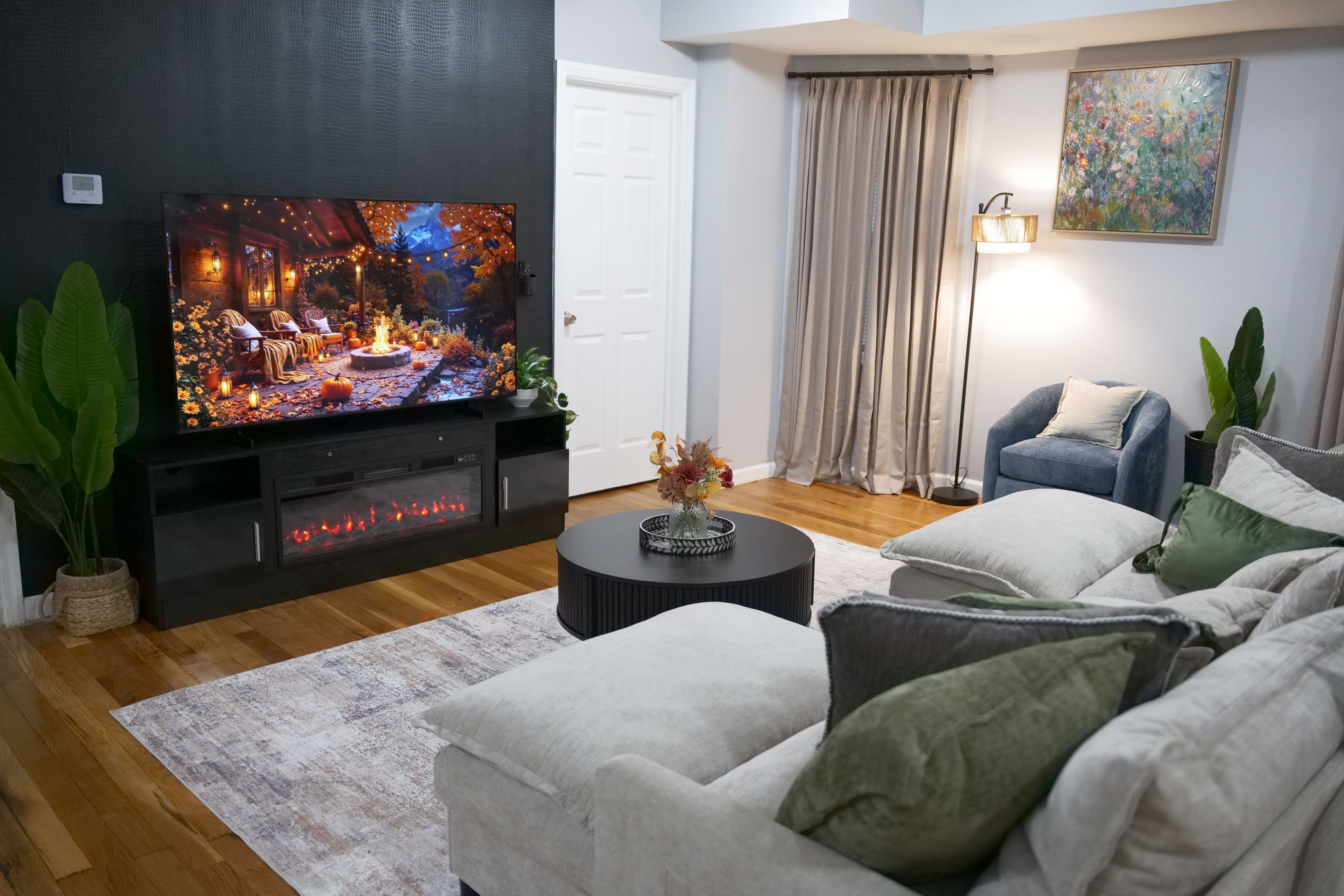 A living room with a flat-screen TV, a fireplace, a sofa, and a coffee table.