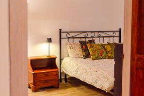 A bedroom with a bed, a nightstand, and a lamp. - Recently renovated apartment with an urban style and an authentic soul.Exposed brick walls warm the atmosphere and give real character to the space.The living area is spacious and welcoming, featuring a fully equipped kitchen, a dining table for 6 guests (Turin)