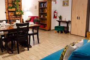 A dining area with a brick wall, wooden bookshelf, and a fire extinguisher. - Recently renovated apartment with an urban style and an authentic soul.Exposed brick walls warm the atmosphere and give real character to the space.The living area is spacious and welcoming, featuring a fully equipped kitchen, a dining table for 6 guests (Turin)