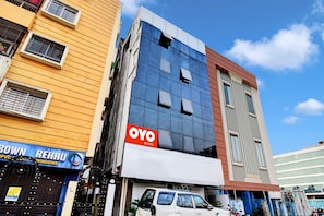 A multi-story building with a sign for 'OYO ROOMS' indicating a hotel or lodging service. - Hotel O Tower Shanavi Inn (Barasat)