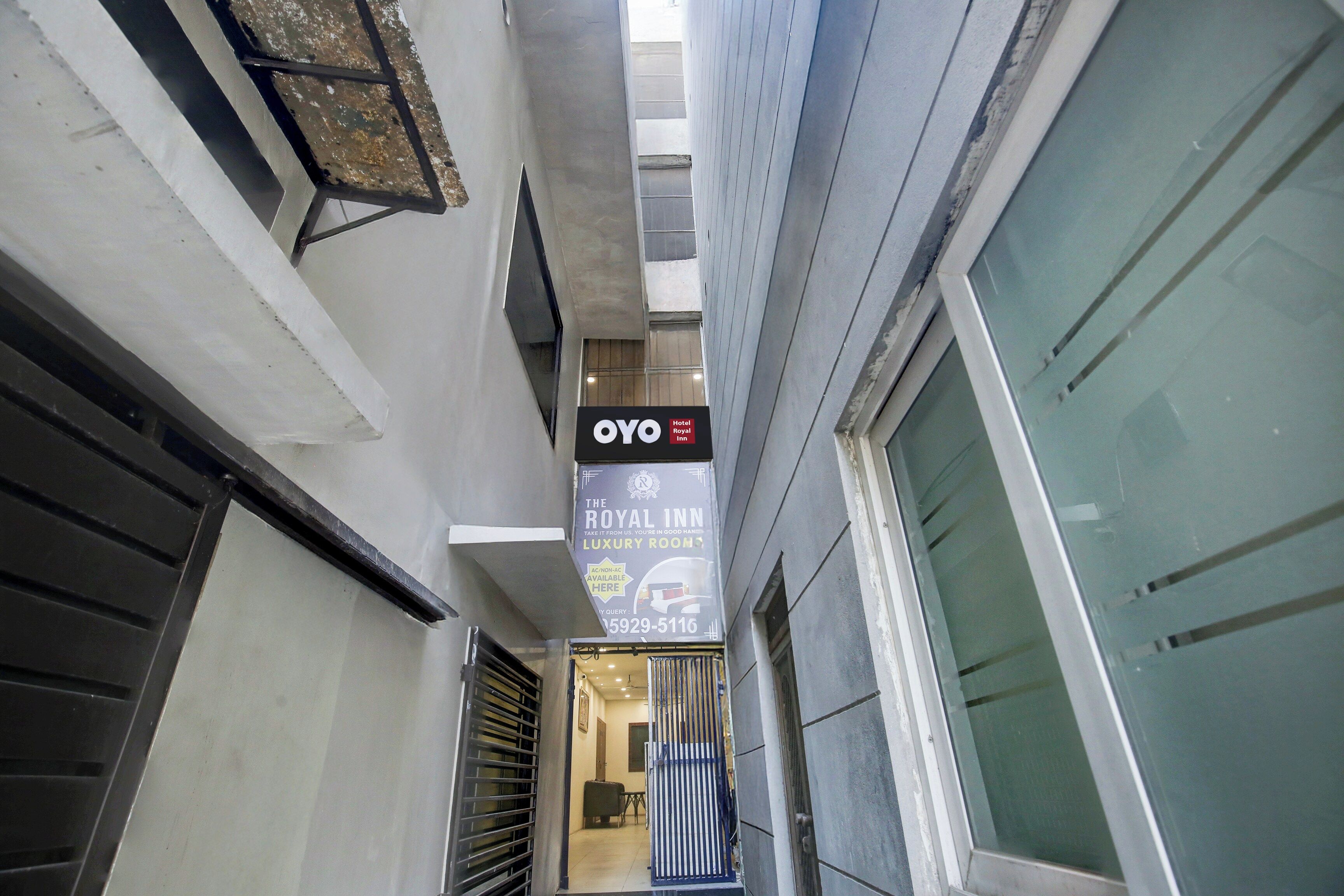 A narrow corridor with a sign for OYO Hotel Royal Inn, indicating a luxury room option.