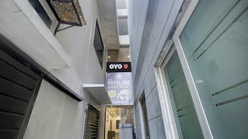 A narrow corridor with a sign for OYO Hotel Royal Inn, indicating a luxury room option.