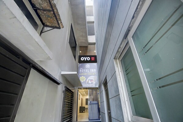 A narrow corridor with a sign for OYO Hotel Royal Inn, indicating a luxury room option.