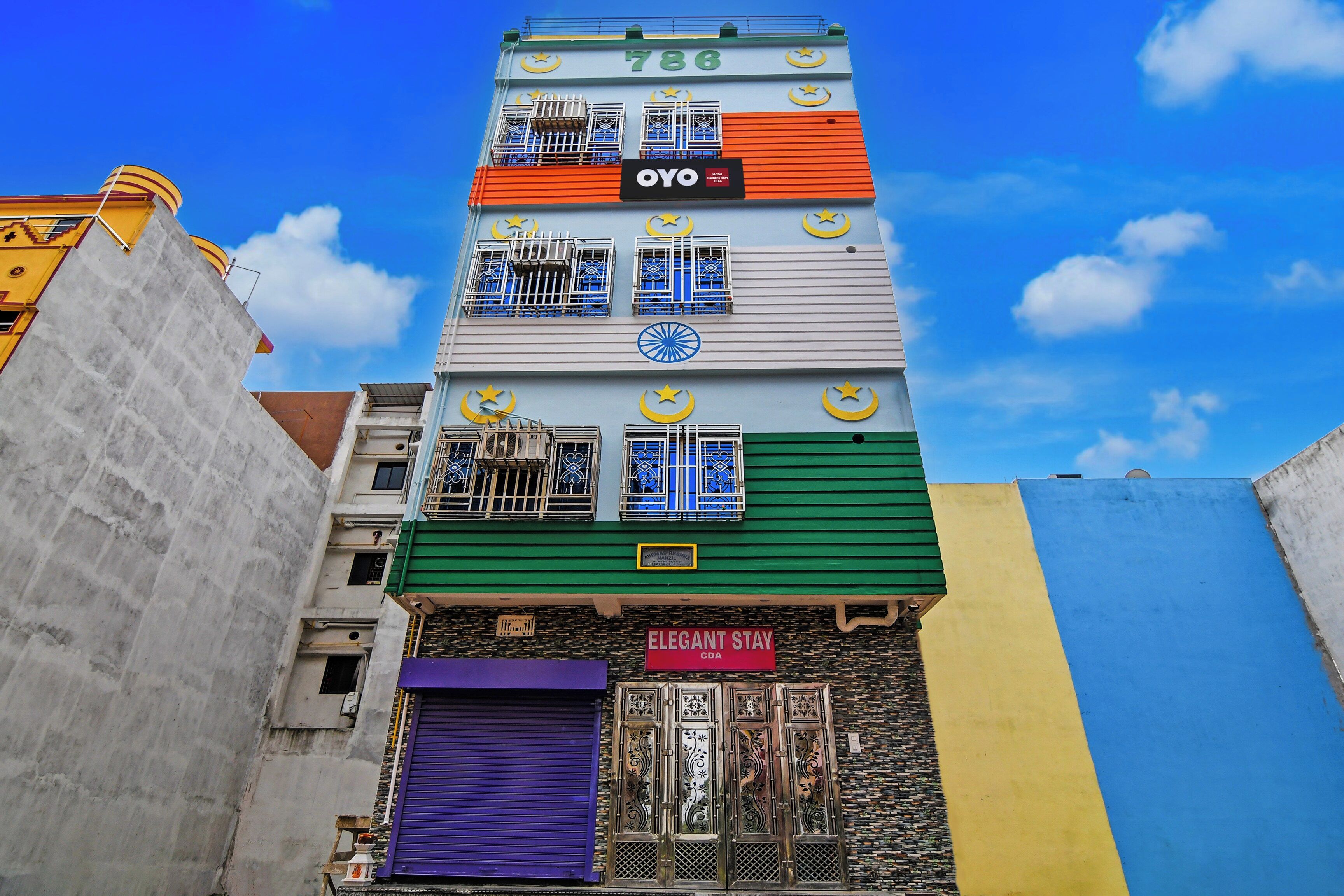 A multi-story building with a prominent sign for 'Hotel OYO' and a 'CDA' sign indicating a nearby establishment.