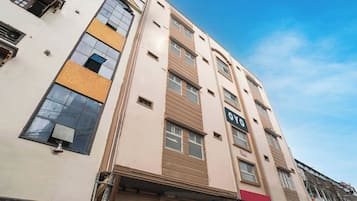Un edificio de varios pisos con un letrero que indica un negocio en la planta baja.