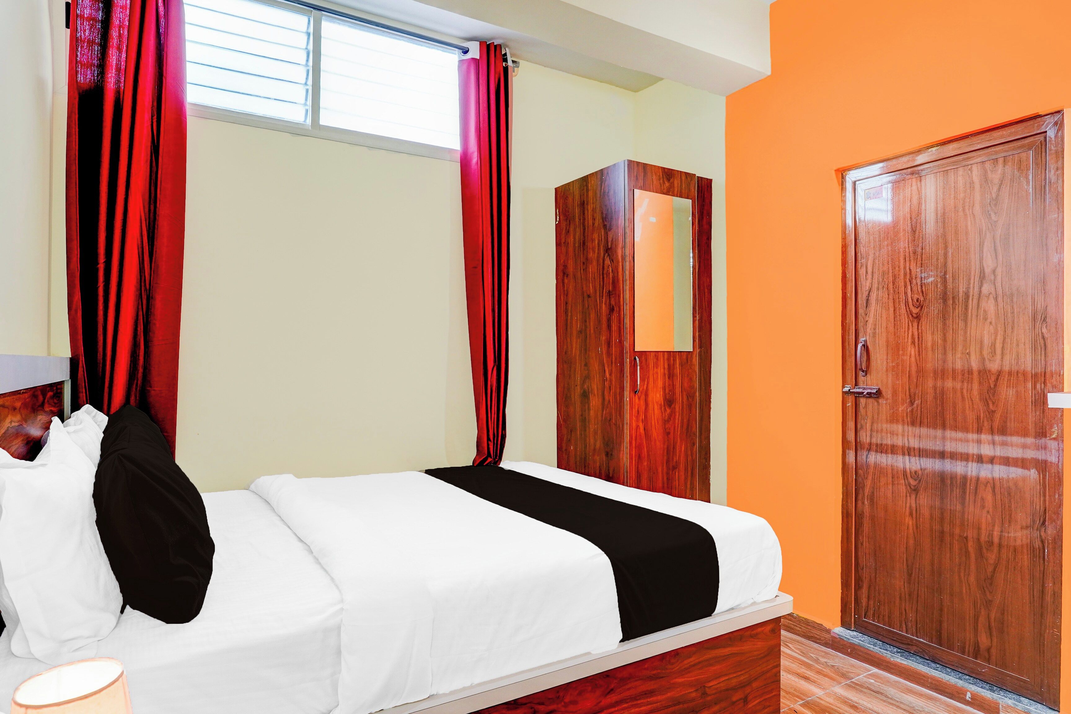 Een hotelkamer met een bed, een kledingkast en een deur.