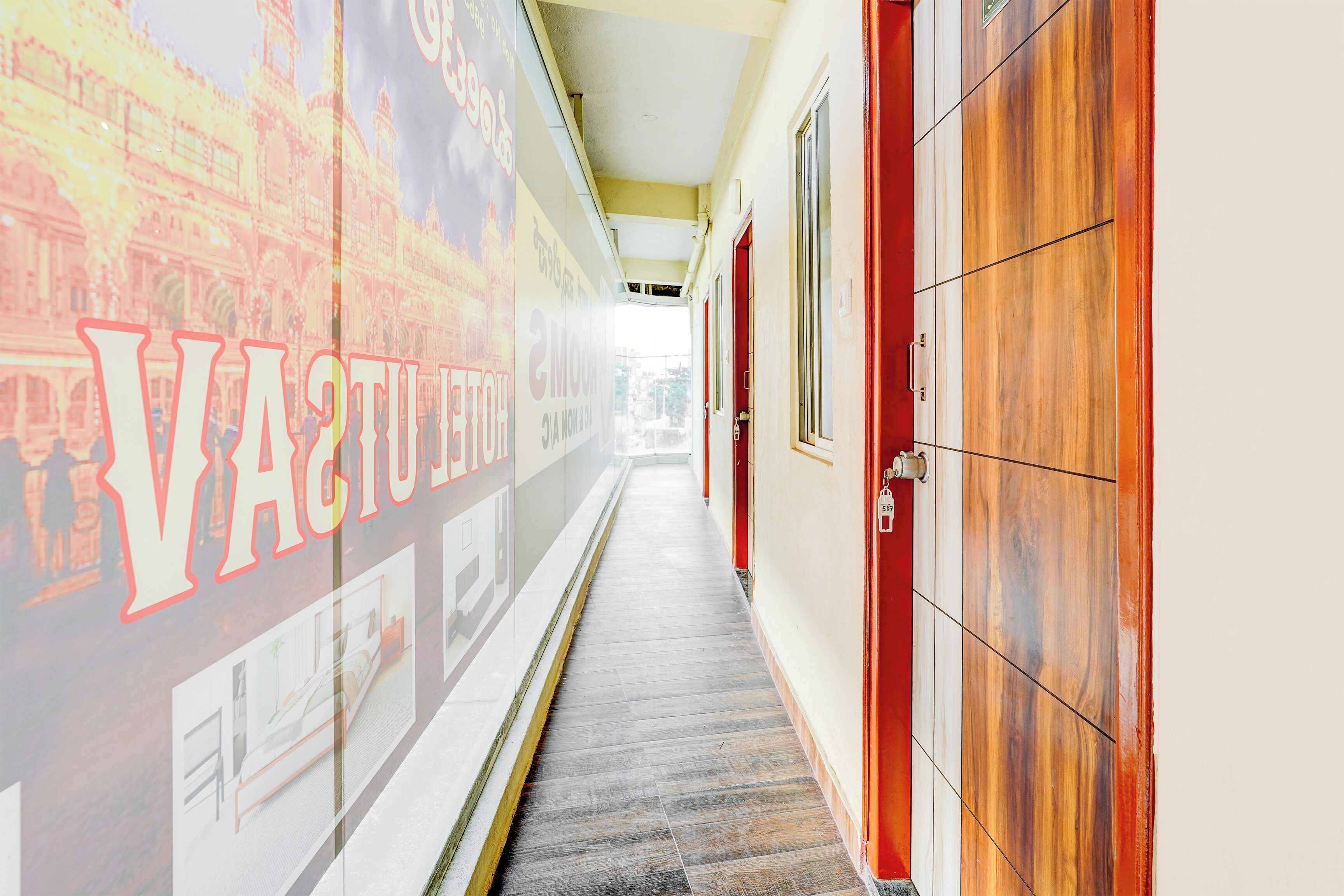 A hallway with a wall mural, wooden doors, and a tiled floor.