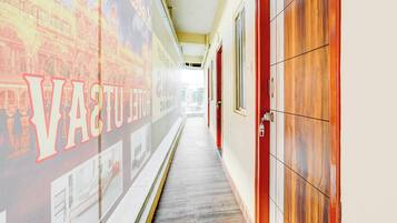 A hallway with a wall mural, wooden doors, and a tiled floor.