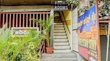 A hotel entrance with a staircase leading to rooms, a sign for 'Hotel Utsai Sway,' and a sign for 'Rooms.'
