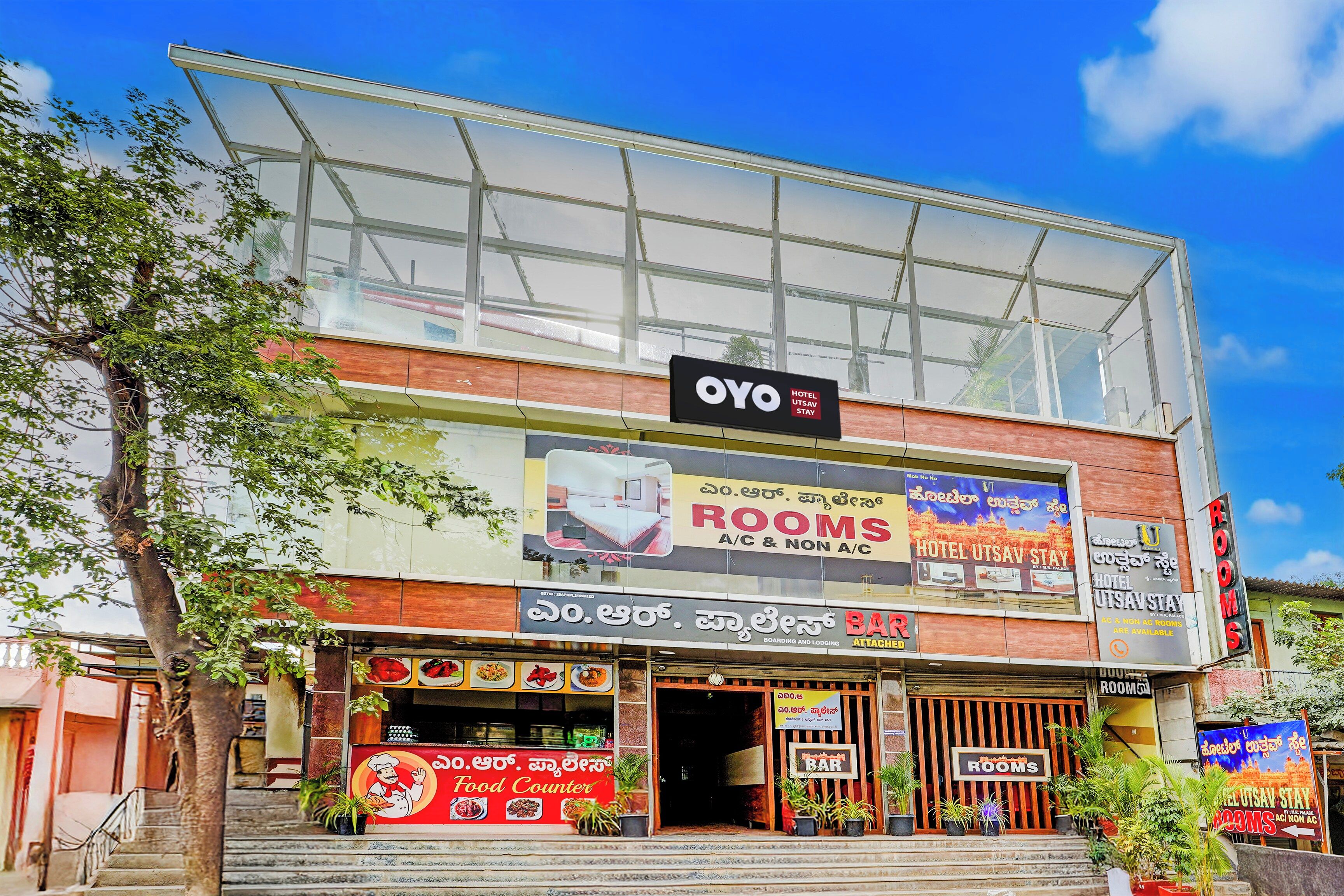 A hotel with a glass facade, multiple signs advertising rooms and a food counter.