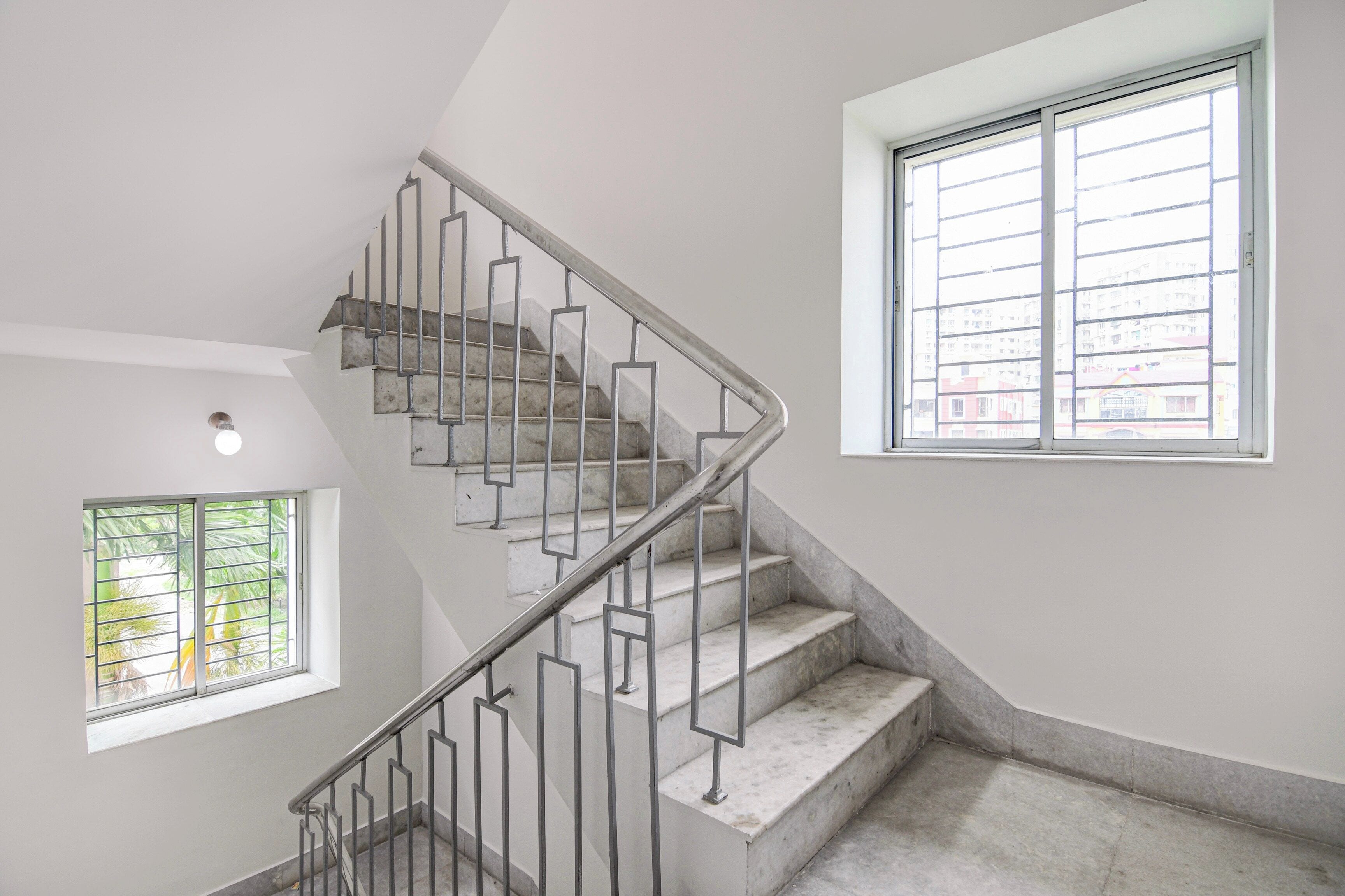 Una escalera con barandillas metálicas que sube a un piso superior.