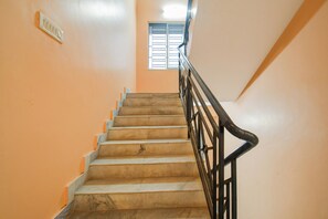 A staircase with a handrail and a window at the top. - Hotel O MOHAR KUNJHA (Barasat)