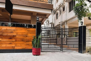 A gated entrance with a wooden wall and a potted plant. - Hotel O MOHAR KUNJHA (Barasat)