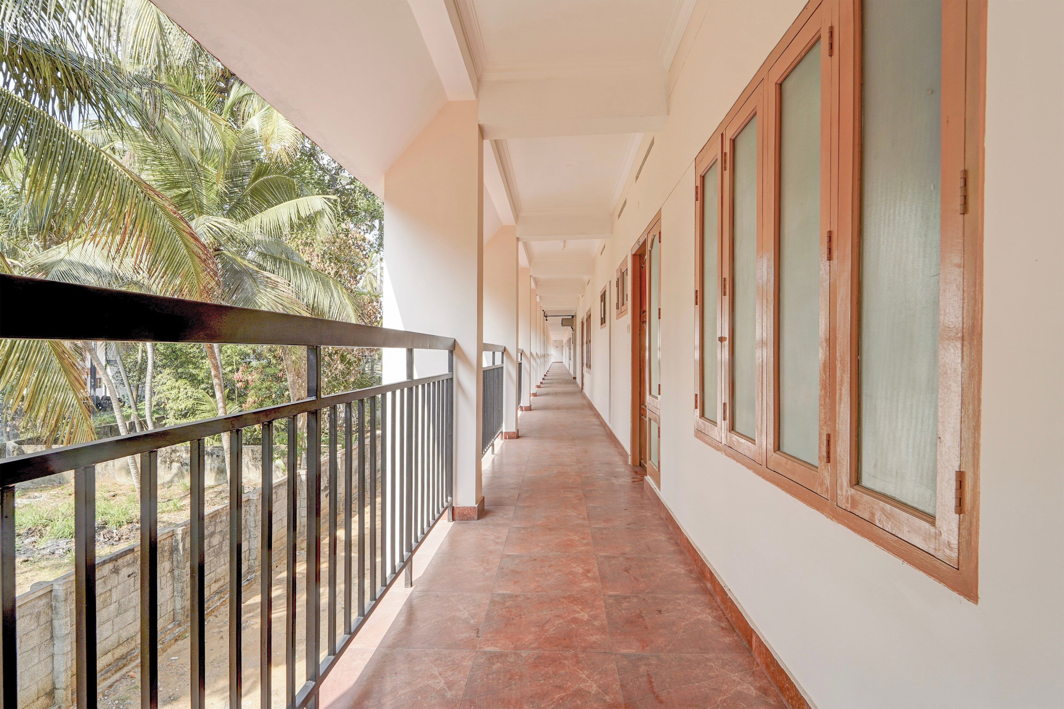 Un couloir avec un balcon d’un côté, qui mène à une série de portes.