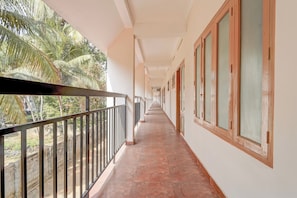 A corridor with a balcony on one side, leading to a series of doors. - Townhouse Kazhakootam (Thiruvananthapuram)