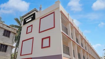 Un immeuble à plusieurs étages, sur lequel on peut lire une enseigne indiquant qu’il s’agit d’une maison de ville gérée par une entreprise.