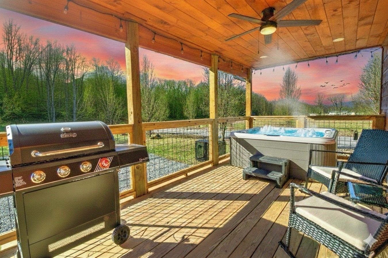 A covered outdoor area with a barbecue grill, a hot tub, and lounge chairs.