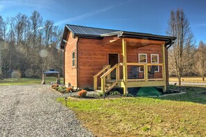 A wooden cabin with a porch and a gravel driveway. - Peaceful Cosby Retreat - Hot Tub, Grill, and More! (Cosby)