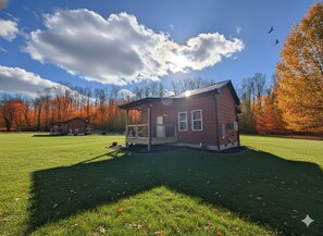 A single-story house with a front porch, a small deck, and a well-maintained lawn. - Peaceful Cosby Retreat - Hot Tub, Grill, and More! (Cosby)