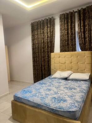 A bedroom with a bed, curtains, and a headboard. - Perfect 2-bedroom apartment in Akure for a relaxing stay (Akure)
