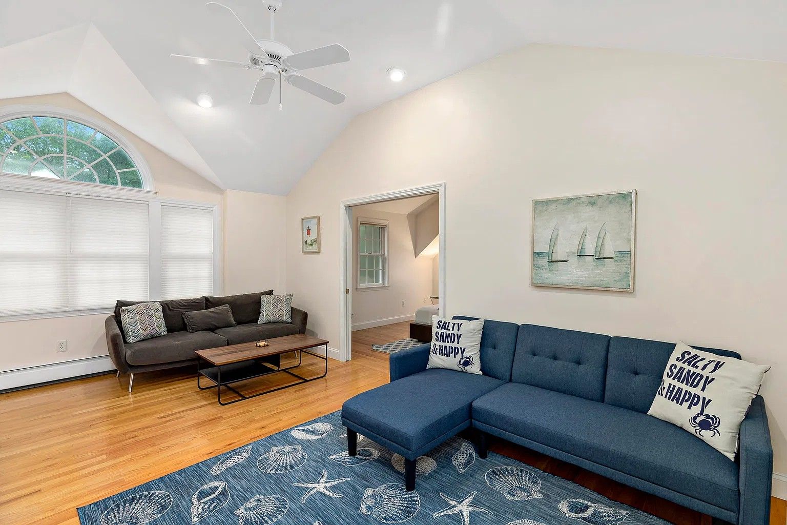 A modern living room with a sectional sofa, a coffee table, and a patterned rug.