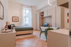 A modern bedroom with a bed, bedside table, and a desk with a chair. - Benny Suite is a renovated studio apartment at Via Alfieri 16b, in the heart of Turin.Elegant, bright, and meticulously detailed, it combines modern design and comfort.You'll find a cozy living/sleeping area, a fully equipped kitchenette, and a bathroom  (Turin)