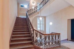 A staircase with ornate metal railings and a wooden handrail. - Benny Suite is a renovated studio apartment at Via Alfieri 16b, in the heart of Turin.Elegant, bright, and meticulously detailed, it combines modern design and comfort.You'll find a cozy living/sleeping area, a fully equipped kitchenette, and a bathroom  (Turin)