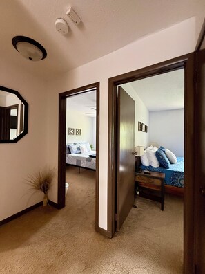 Ein Hotelzimmer mit Bett, Nachttisch, Lampe und Spiegel an der Wand.