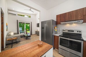 Eine moderne Küche mit Einbauofen, Edelstahlkühlschrank und Holzschränken.