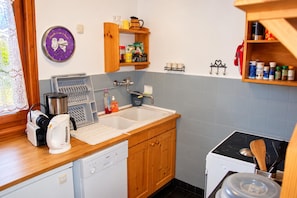 A kitchen with a sink, coffee maker, dishwasher, and wooden cabinets. - New Listing (Chamonix-Mont-Blanc)
