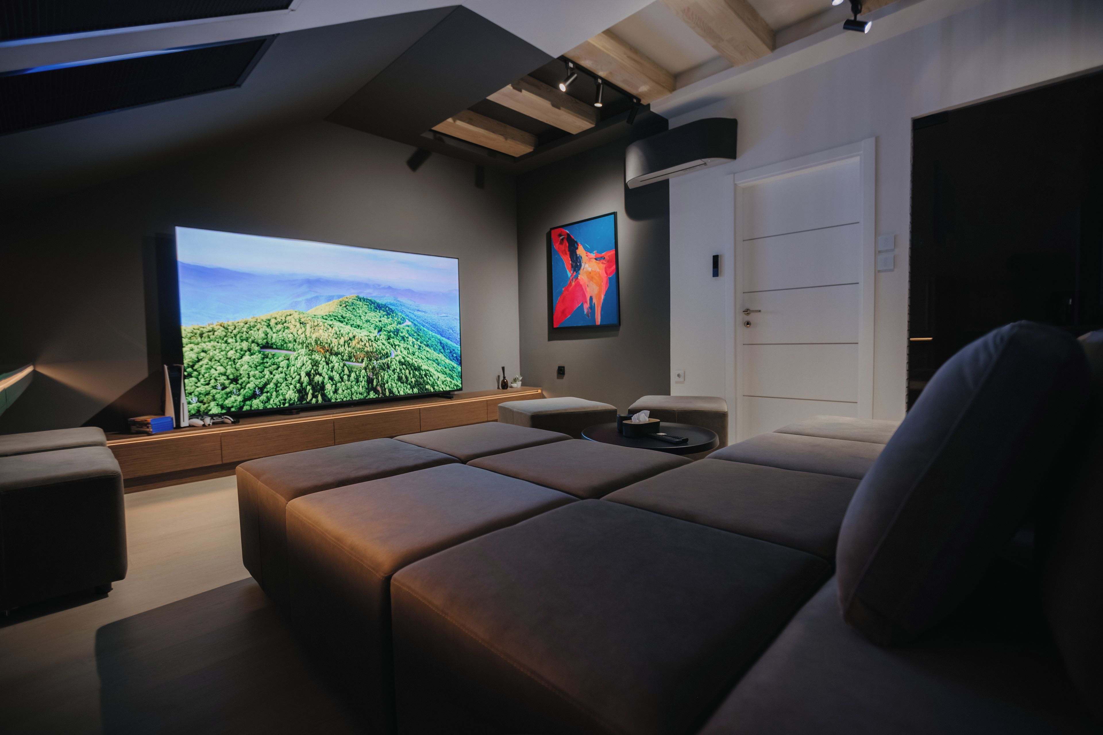 Una sala de estar moderna con un televisor de pantalla plana grande, un sofá cómodo y un diseño minimalista.