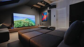 Una sala de estar moderna con un televisor de pantalla plana grande, un sofá cómodo y un diseño minimalista.