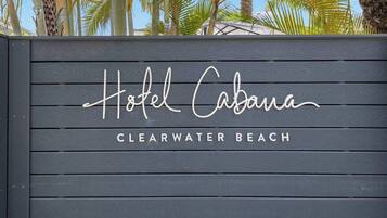 Une enseigne en bois portant l’inscription « Hôtel Cabana » et « CLEARWATER BEACH », indiquant le nom et l’emplacement de l’hôtel.