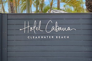 Ein Holzschild mit der Aufschrift 'Hotel Cabana' und 'CLEARWATER BEACH', das den Namen und den Standort des Hotels angibt.