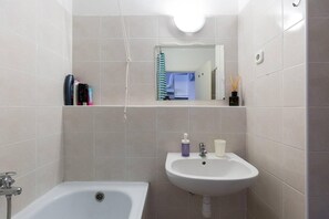Ein Badezimmer mit Badewanne, Waschbecken und Spiegel.