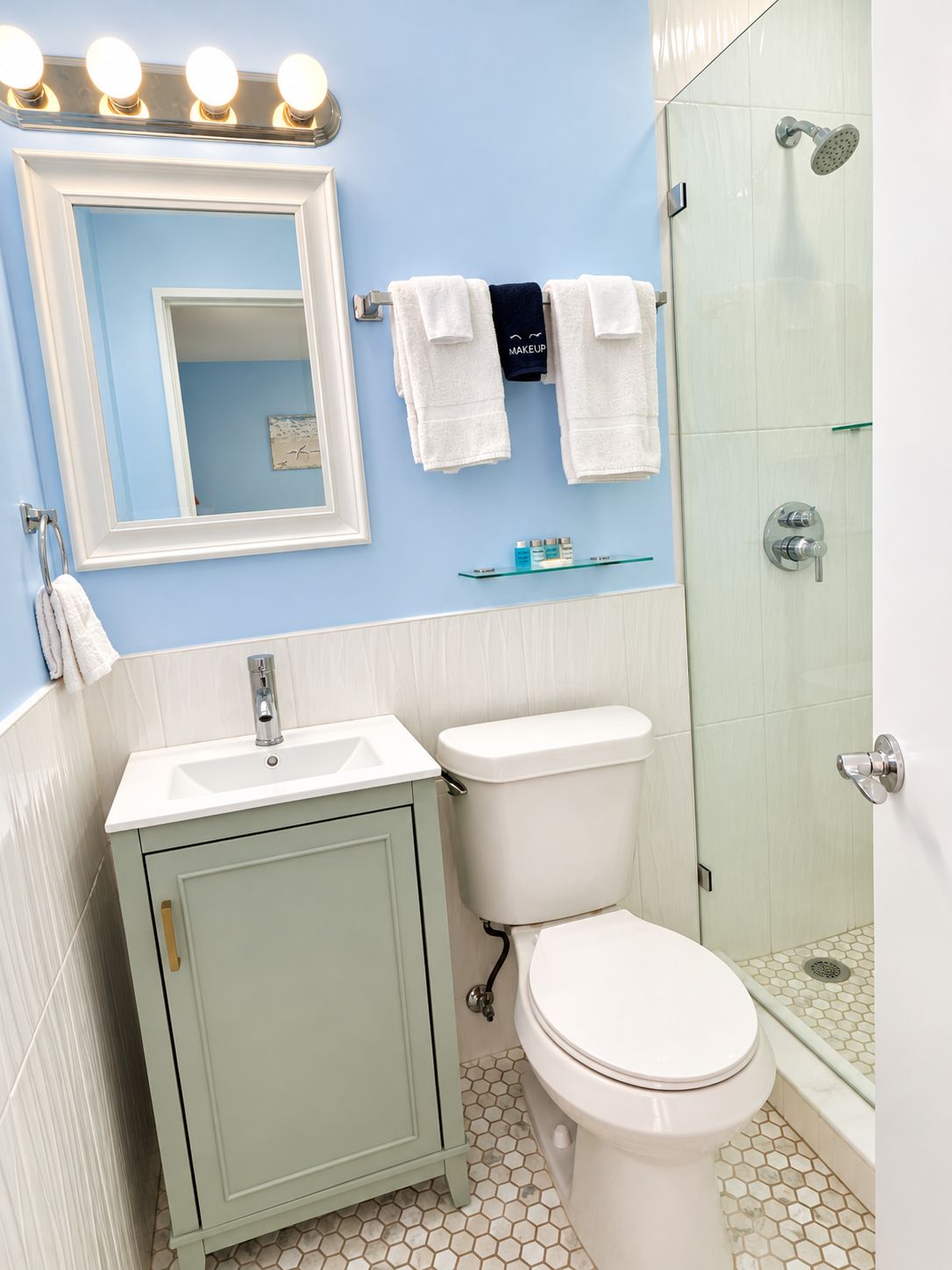 A bathroom with a sink, toilet, and a glass-enclosed shower.
