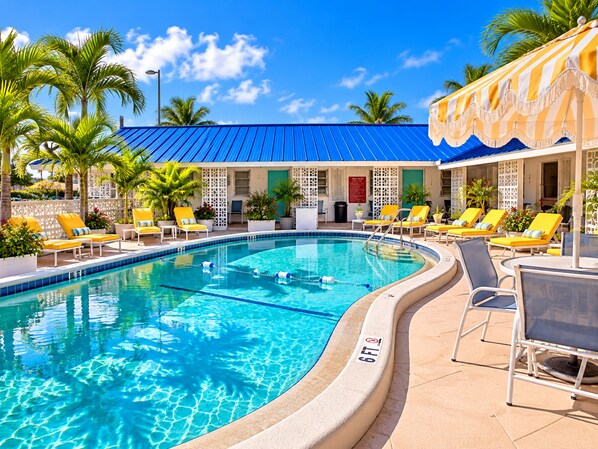 A swimming pool with lounge chairs and palm trees. - Sunny Beach Inn - Ebb Tide Inn (Treasure Island)
