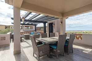 Une terrasse extérieure aménagée avec des meubles en osier et offrant une vue sur le paysage.