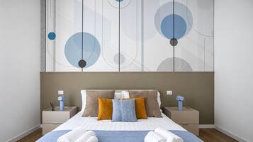 Camera d'albergo moderna con un letto grande, due comodini e una parete decorata con arte astratta.