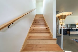 A wooden staircase with a handrail and a modern lamp in the background. - Private Jacuzzi Surrounded by Oaks Trees (Three Rivers)