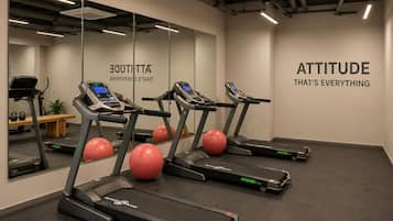 A gym with treadmills, exercise balls, and motivational wall text.