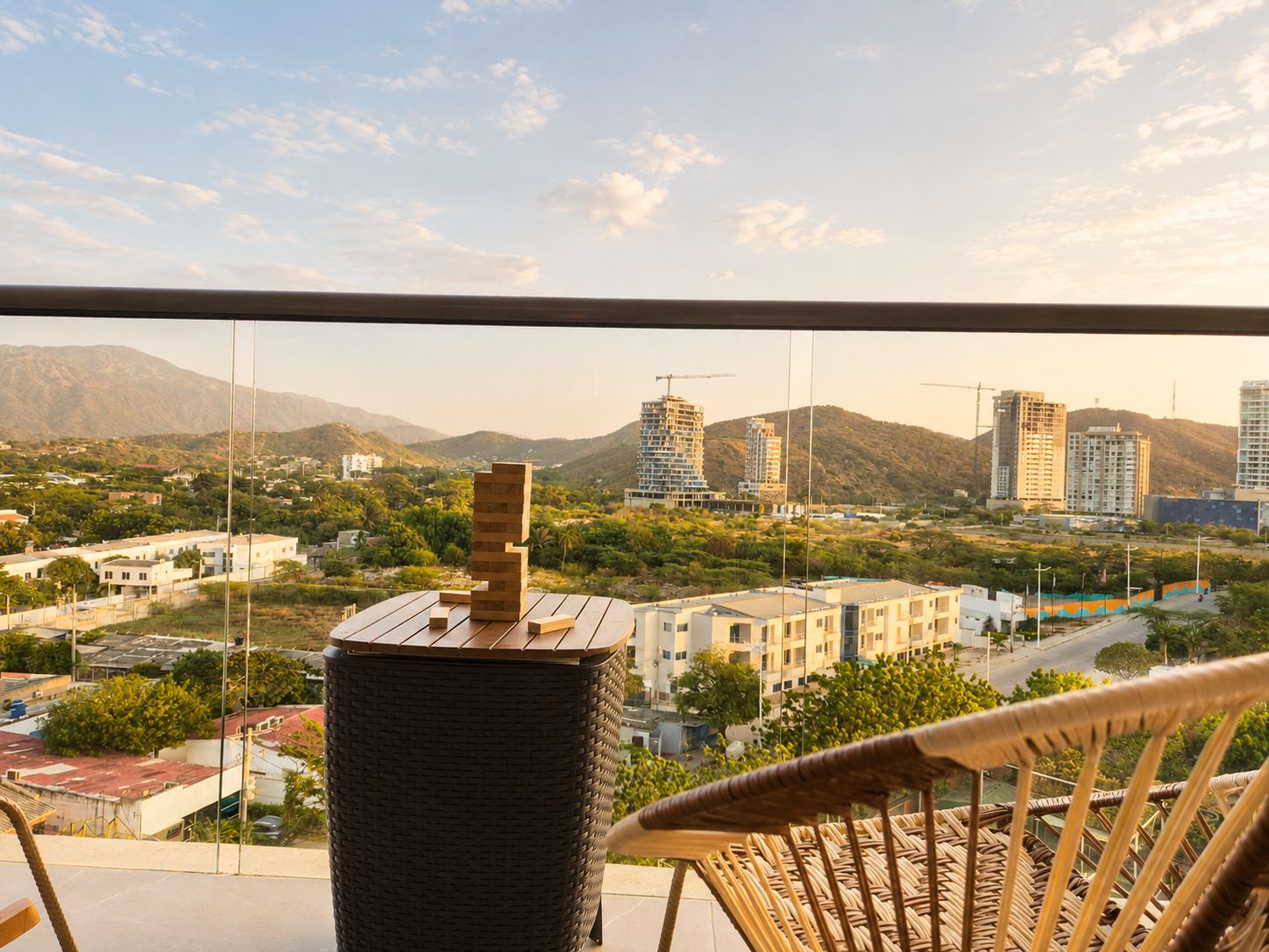 Ein Balkon mit Blick auf eine Stadtlandschaft, einschließlich Gebäude und Berge.