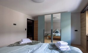 A bedroom with a bed, a wardrobe, and a mirror. - PEACEFUL ZERMATT ESCAPE JUST MINUTES FROM SUNNEGGA & THE STATION (Zermatt)