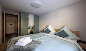 A bedroom with a bed, pillows, a fluffy rug, and a wardrobe. - PEACEFUL ZERMATT ESCAPE JUST MINUTES FROM SUNNEGGA & THE STATION (Zermatt)