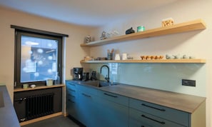A modern kitchen with a window, built-in appliances, and decorative items on shelves. - PEACEFUL ZERMATT ESCAPE JUST MINUTES FROM SUNNEGGA & THE STATION (Zermatt)