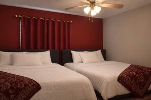 A hotel room with two beds, a ceiling fan, and red curtains. - Rosie Blush 1BR 2 Beds | 5 Min Walk NRG | Near TMC (Houston)