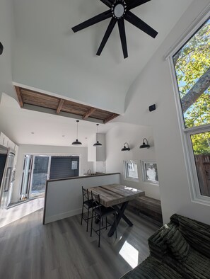 Cucina spaziosa con isola centrale, illuminazione a sospensione e ventola a soffitto.