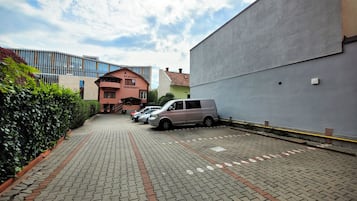Una strada asfaltata conduce a un edificio con un cartello che riporta 'Pensionia DOROBANTI'.