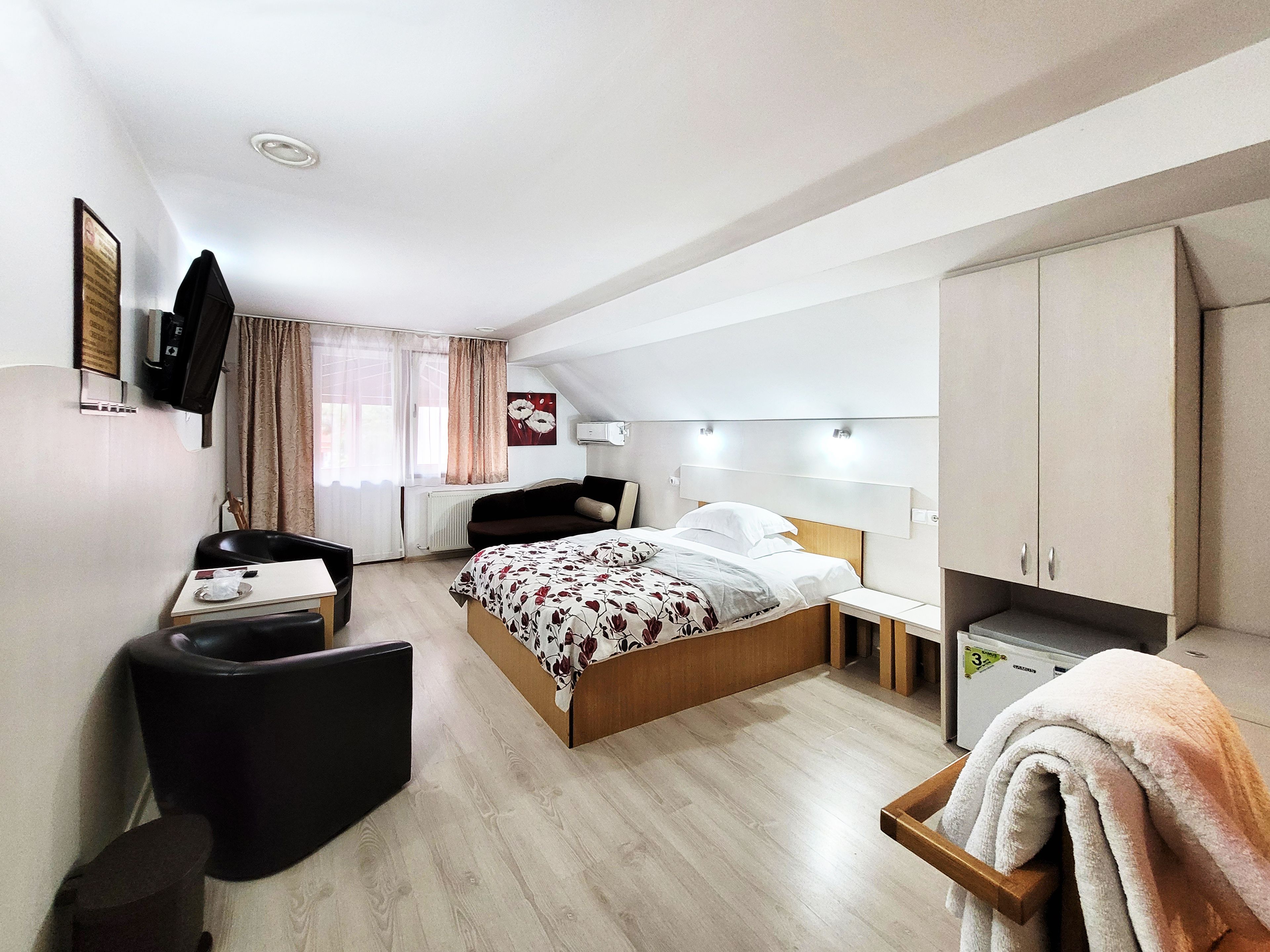 A modern bedroom with a bed, bedside table, and a desk with a chair.