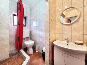 Une salle de bain avec des toilettes, un lavabo et un miroir.